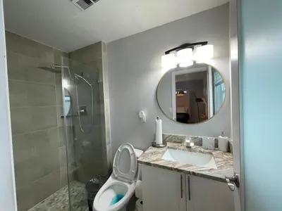 a bathroom with a toilet and a sink and a shower at Spacious 4BR Home 5 Min from Hard Rock Stadium in Miami Gardens