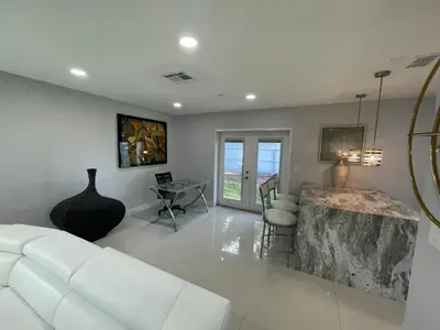 a living room with a white couch and a table at Spacious 4BR Home 5 Min from Hard Rock Stadium in Miami Gardens