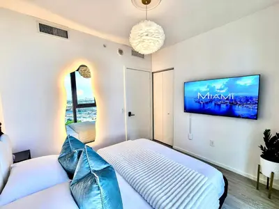 a bedroom with two beds and a tv on the wall at Electric Luxury Downtown Bayfront Brickell in Miami