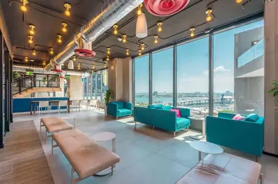a room with chairs and tables and large windows at Electric Luxury Downtown Bayfront Brickell in Miami