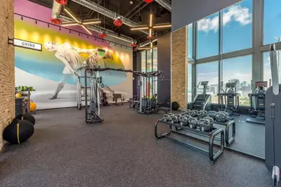a gym with several tread machines and a mural at Electric Luxury Downtown Bayfront Brickell in Miami