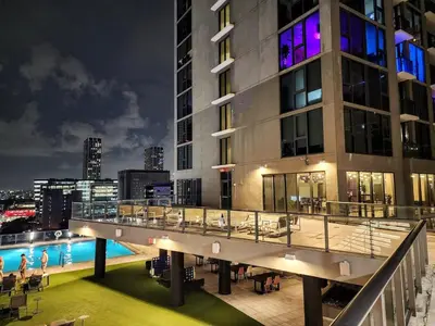 a view of a building with a pool at night at Electric Luxury Downtown Bayfront Brickell in Miami