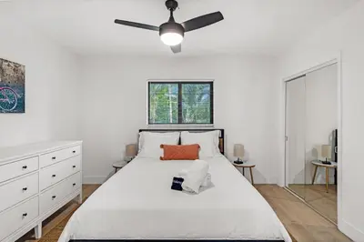 a bedroom with a white bed with a ceiling fan at Comfort and Space Fort Lauderdale Miami in Fort Lauderdale