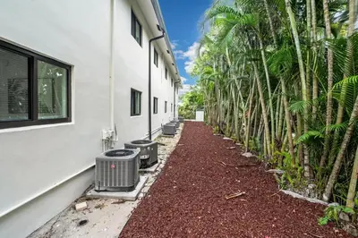 a long alley with palm trees next to a building at Comfort and Space Fort Lauderdale Miami in Fort Lauderdale