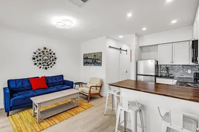a living room with a blue couch and a kitchen at Comfort and Space Fort Lauderdale Miami in Fort Lauderdale
