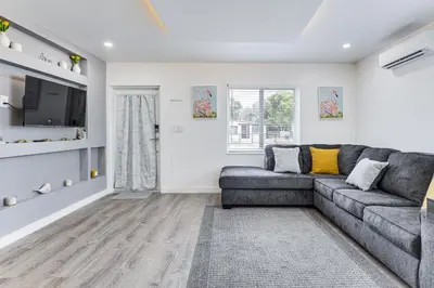 a living room with a couch and a tv at 8 Mi to Design District Miami Home with Yard in Miami
