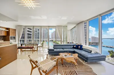 a living room with a blue couch and a table at Sublime Ocean & Pool View Unit At Icon Brickell in Miami