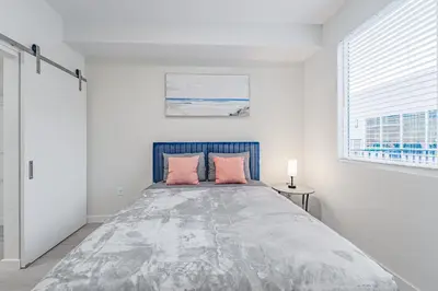 a bedroom with a large bed with pink pillows at Devereaux Miami Luxury 2 Bedroom Apartment in Biscayne Gardens