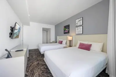 a hotel room with two beds and a desk at Luxury 2BR Beachfront Rooftop Pool and Spa in Hollywood