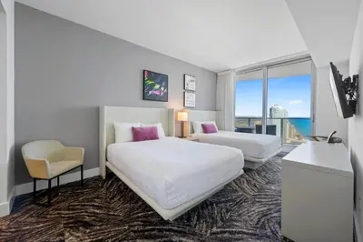a hotel room with two beds and a chair at Luxury 2BR Beachfront Rooftop Pool and Spa in Hollywood