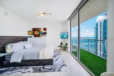 a bedroom with a large bed and a balcony at Top Floor Front Facing Penthouse With Breathtaking Views in Miami