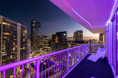 a purple balcony with a view of the city at night at Top Floor Front Facing Penthouse With Breathtaking Views in Miami