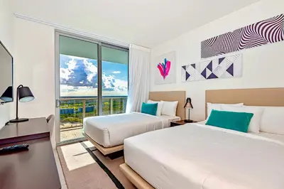 two beds in a room with a window at Modern Condo Retreat with Ample Space in Hollywood