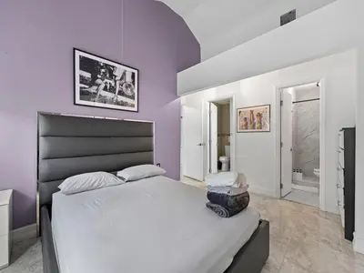 a bedroom with a large bed with purple walls at The Velvet Palm Midtown Pool and Hot Tub in Miami