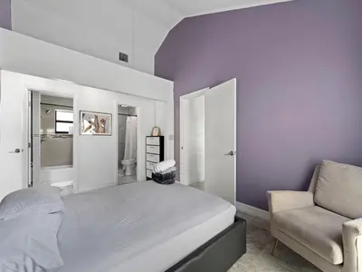 a bedroom with a large bed and a chair at The Velvet Palm Midtown Pool and Hot Tub in Miami