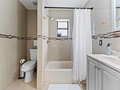 a bathroom with a tub and a toilet and a sink at The Velvet Palm Midtown Pool and Hot Tub in Miami