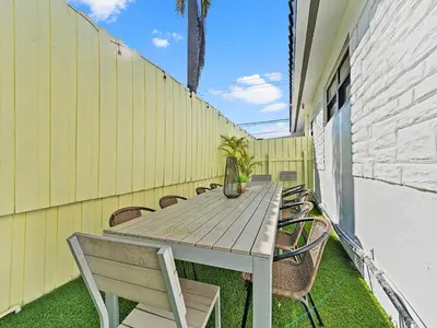 a wooden table and chairs on a patio at The Velvet Palm Midtown Pool and Hot Tub in Miami