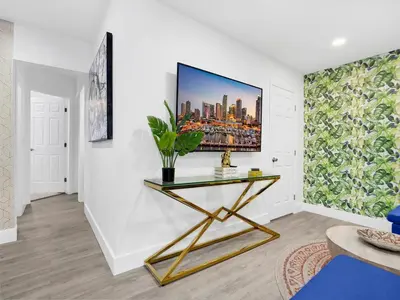 a living room with a table with a painting on the wall at Bungalow House 6 BR Pool Little Havana in Miami