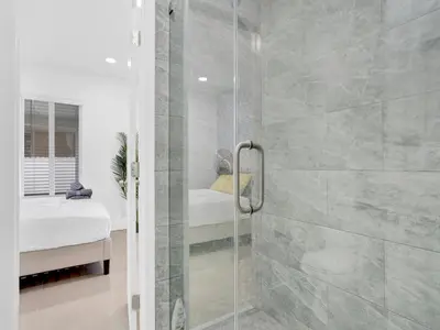 a shower with a glass door in a bathroom at Bungalow House 6 BR Pool Little Havana in Miami