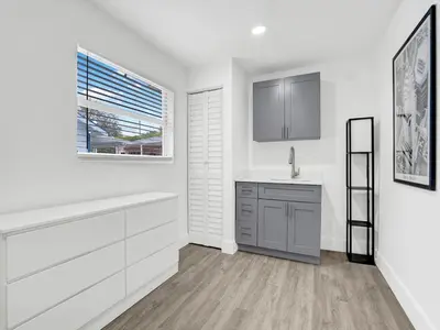 a kitchen with white cabinets and a sink and a window at Bungalow House 6 BR Pool Little Havana in Miami