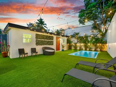 a backyard with a swimming pool and green grass at La Pergola Villa 7 BR PoolHot Tub Location in Miami