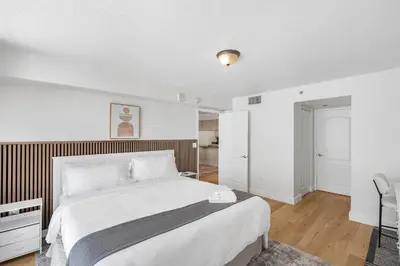 a bedroom with a large white bed with a wooden headboard at Enjoy Pool and Stunning City Views in Brickell in Miami