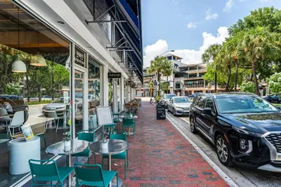 a street with tables and chairs and a car parked on a sidewalk at Sunset Suite Skyline Views King and Twin Sofa Includes Parking in Miami
