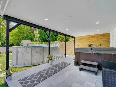a patio with a bench and a swimming pool at Canal Views from Pool w BBQ and Pit Miami Escape in Kendale Lakes