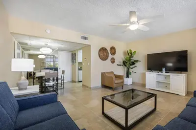 a living room with a blue couch and a tv at Coconut Bay Resort in Fort Lauderdale