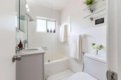 a white bathroom with a tub and a sink and a toilet at Stylish 3BR Home - BBQ & Near Top Attractions in Miami Gardens