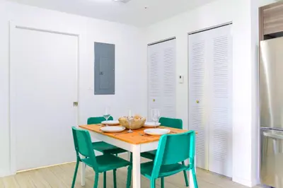 a dining room with a wooden table and green chairs at Contemporary Condo in Wynwood w Free Parking in Miami