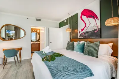 a bedroom with a bed and a pink flamingo painting on the wall at Elegant 2BR Condo at Hotel Arya Full Kitchen Wraparound Views 2 Parking Spots in Miami