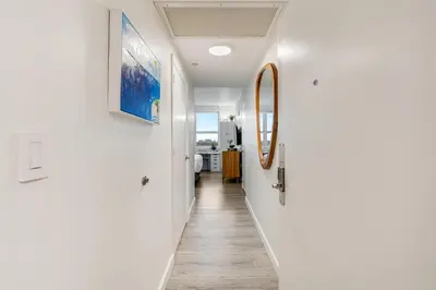 a hallway of a house with white walls and wooden floors at Stylish Studio King Bed City View Hotel Perks Parking in Miami