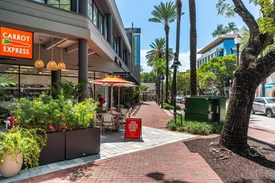 a sidewalk with tables and chairs on a city street at Stylish Studio King Bed City View Hotel Perks Parking in Miami