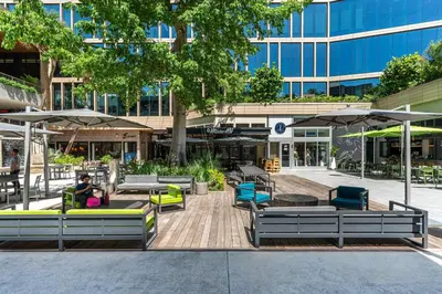 a courtyard with chairs and umbrellas in front of a building at Stylish Studio King Bed City View Hotel Perks Parking in Miami