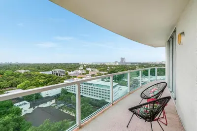 two chairs on a balcony with a view of a city at Bright 1BR in Coconut Grove King Bed Views Pool and Parking in Miami