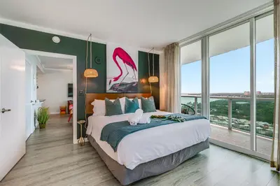 a bedroom with a large bed and large windows at Modern 3BR 3BA Grove Condo Views Balconies Full Kitchen 3 Parking in Miami