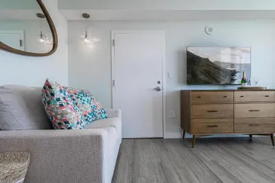 a living room with a couch and a dresser and a mirror at Modern 3BR 3BA Grove Condo Views Balconies Full Kitchen 3 Parking in Miami
