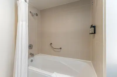 a bathroom with a bath tub with a shower curtain at Cozy Grove Stay Free Parking Pool Access Walk to Cafes and Parks in Miami