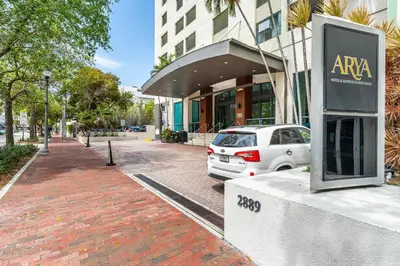 a white car parked in front of a building at Cozy Grove Stay Free Parking Pool Access Walk to Cafes and Parks in Miami