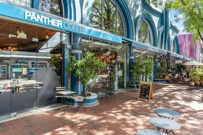 a market with tables and chairs in front of a building at Cozy Grove Stay Free Parking Pool Access Walk to Cafes and Parks in Miami