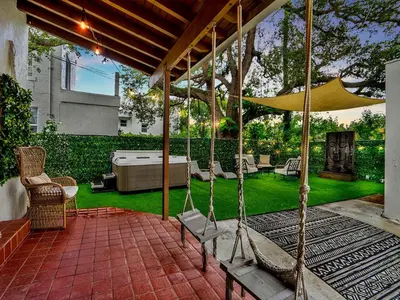 a patio with a hammock and chairs on a lawn at Casa Verde Design District 5BR Hot Tub in Miami