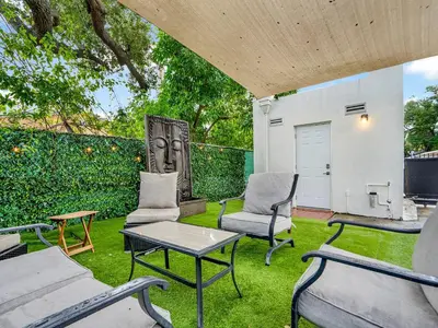 a patio with chairs and a table and a garage at Casa Verde Design District 5BR Hot Tub in Miami