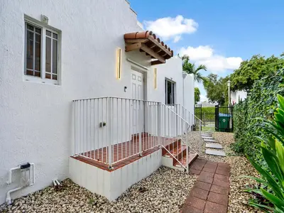 a white house with a gate and a fence at Casa Verde Design District 5BR Hot Tub in Miami