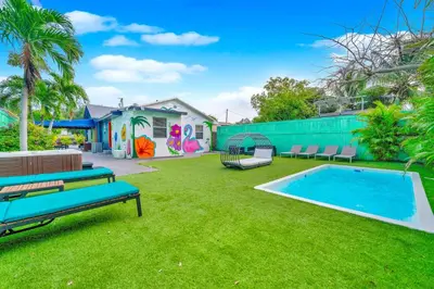 a backyard with a swimming pool and a playground at La Casa Flora Private PoolHot tubSleeps 18 in Miami
