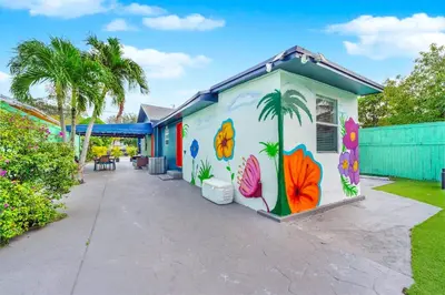 a house with a painting on the side of it at La Casa Flora Private PoolHot tubSleeps 18 in Miami