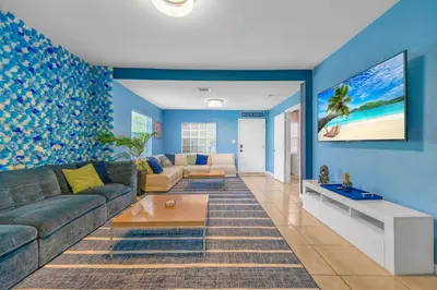 a living room with blue walls and a couch at La Casa Flora Private PoolHot tubSleeps 18 in Miami