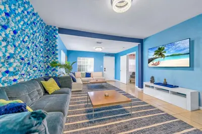 a living room with a couch and a table at La Casa Flora Private PoolHot tubSleeps 18 in Miami