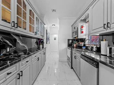a large kitchen with white cabinets and appliances at Villa Ciao Bella Sleeps 25 Pool Hot Tub in Miami