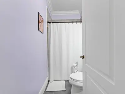 a white bathroom with a toilet and a shower at Villa Ciao Bella Sleeps 25 Pool Hot Tub in Miami